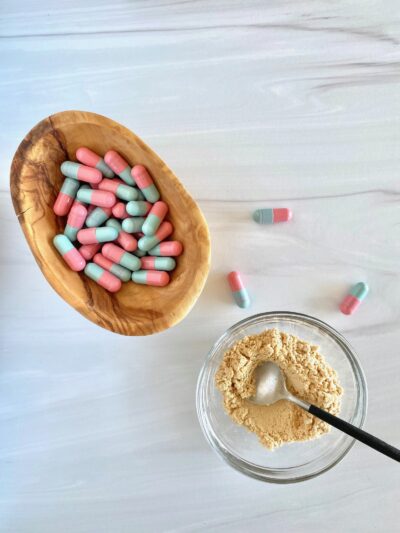 pink and blue capsules in a small wooden bowl